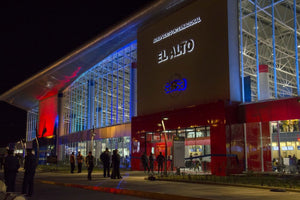 Modern building exterior with 'El Alto Airport' branding at night.