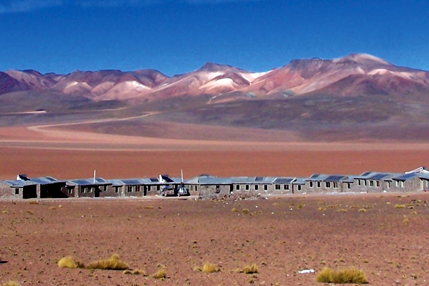Desert landscape with a hotel and mountains in the background at South Lipez