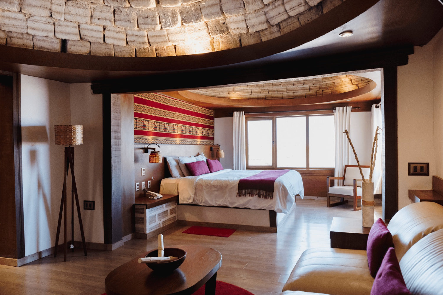 Modern bedroom with stone ceiling, bed, and sitting area at sal hotel