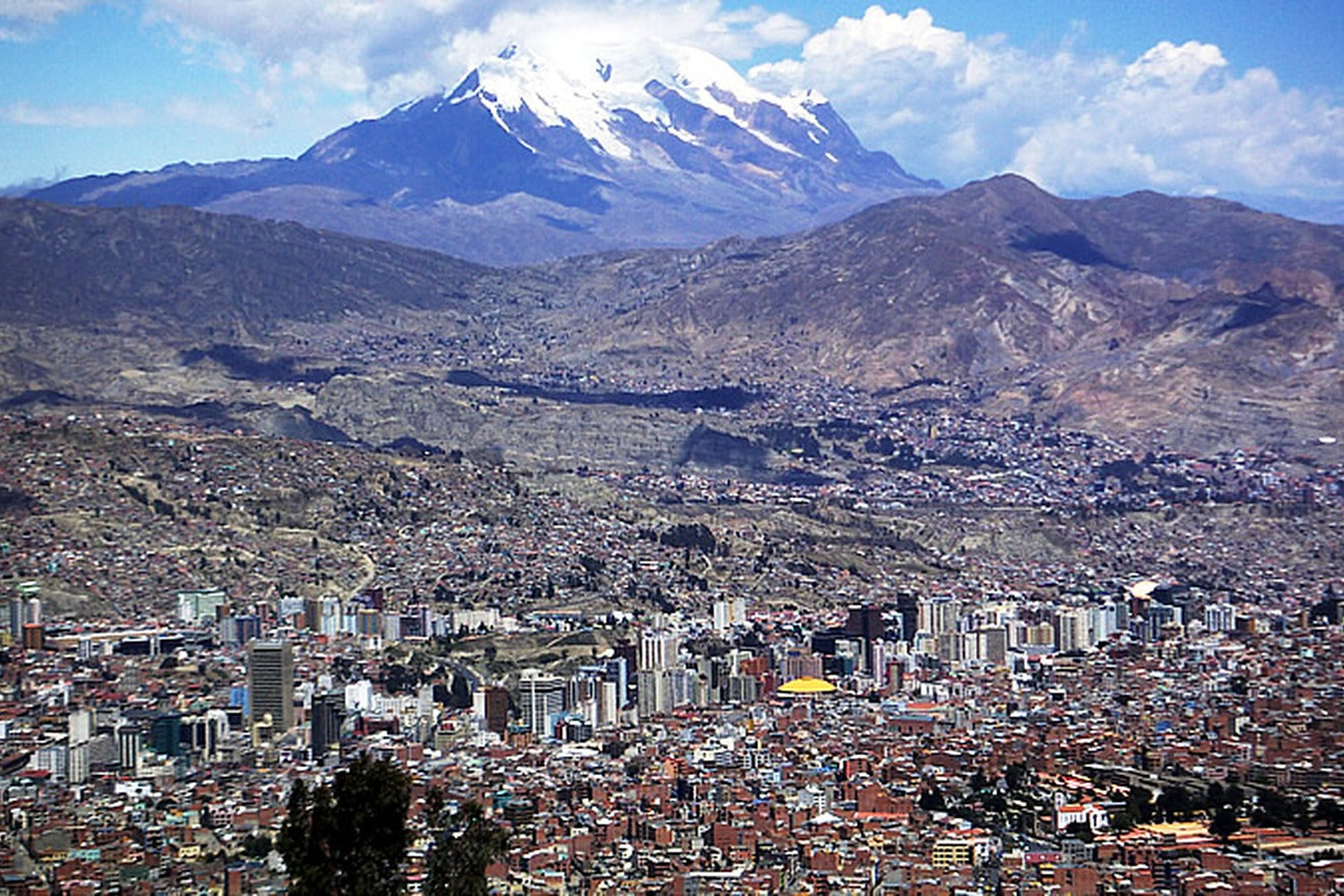 Panoramic view of La Paz with majestic Illimani dominating the horizon.