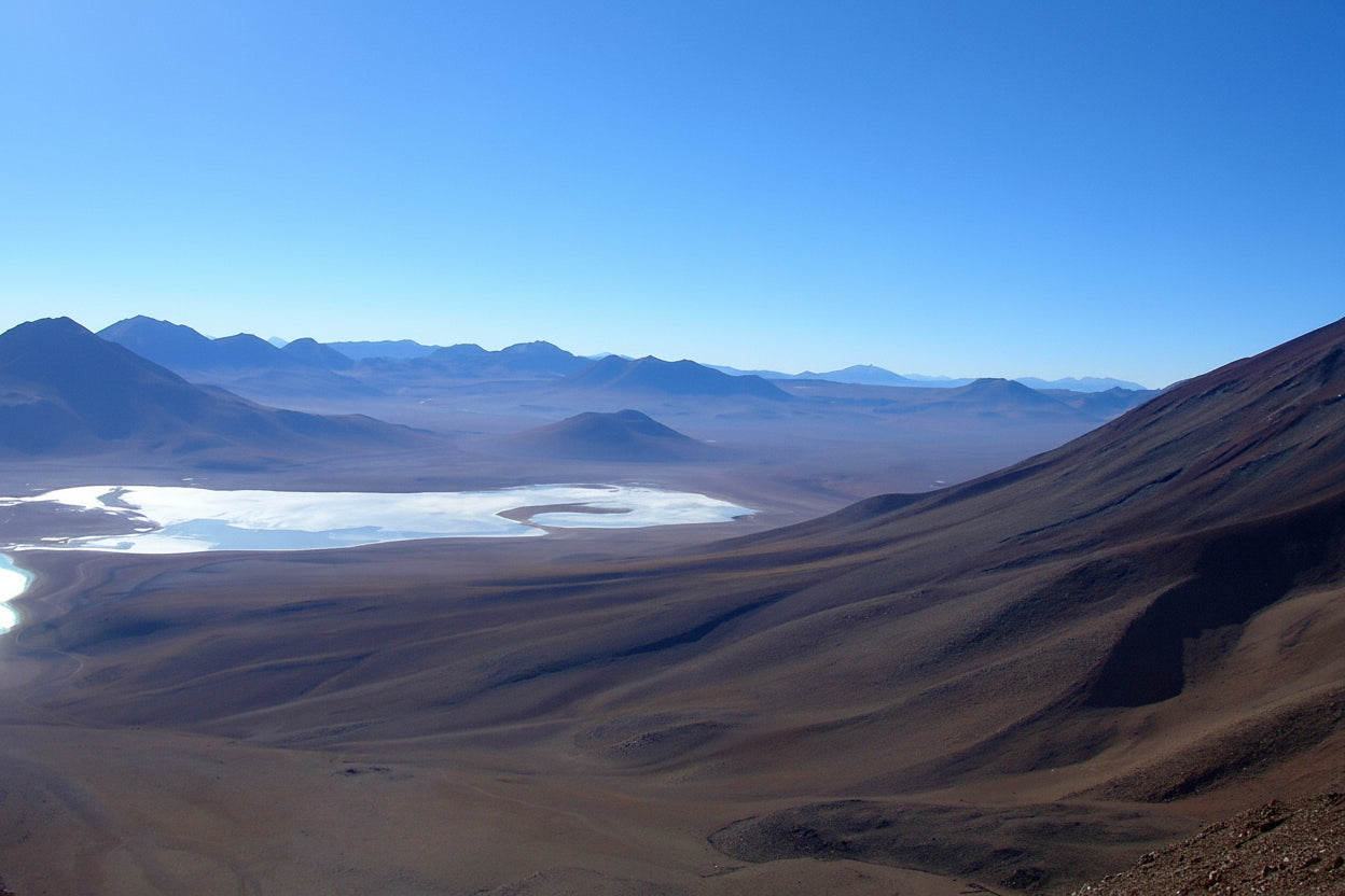 South Lipez desert landscape with mountains and laguna blanca under a clear blue sky.