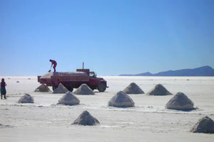 Local workers harvesting salt in the Uyuni Salt Flats using traditional artisanal extraction techniques.