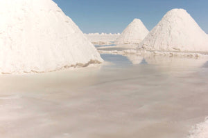 Salt formations in a salt lake with clear blue sky.