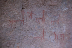 Rock art with red markings on a textured stone surface at South Lipez