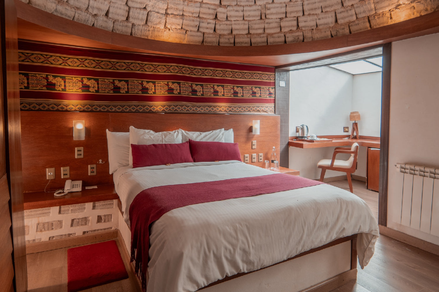 Bedroom with wooden walls and a bed with red and white bedding at sal hotel
