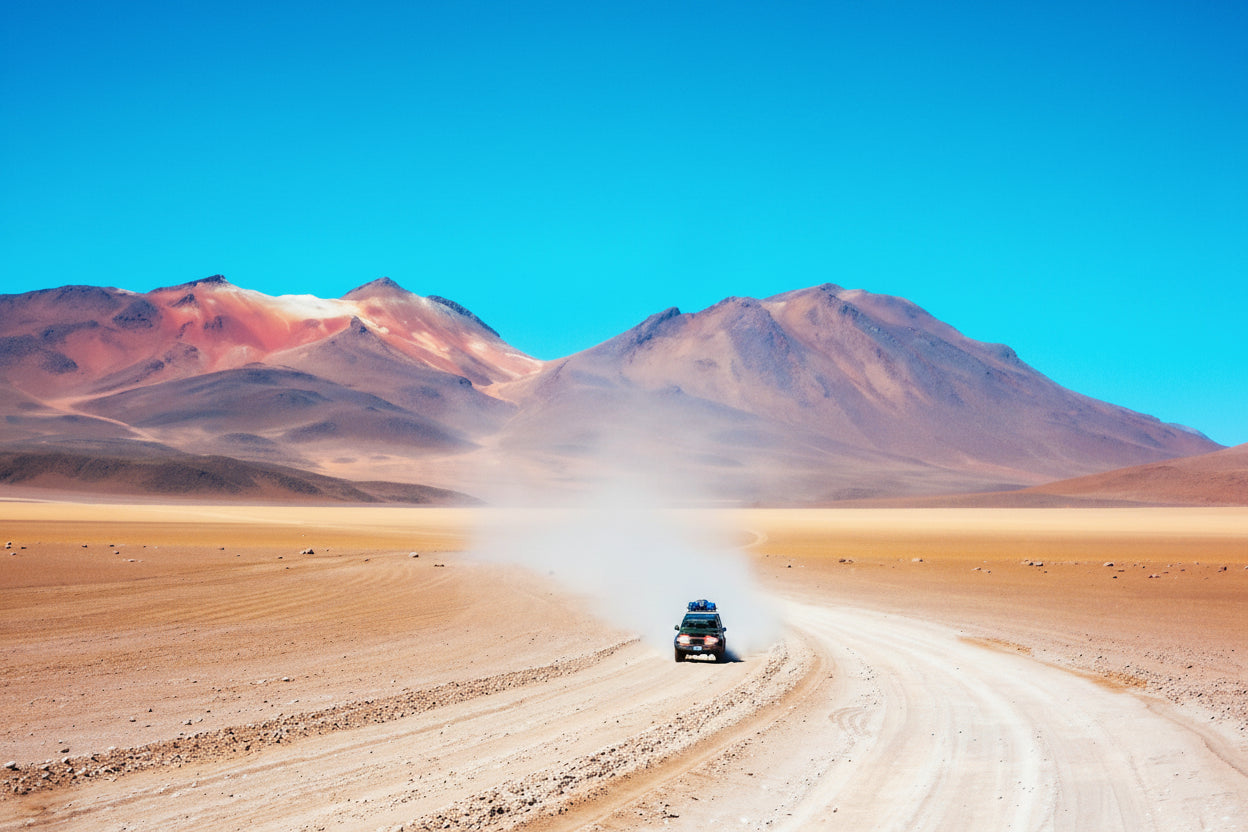 South Lipez desert landscape with a vehicle on a dirt road under a clear blue sky.