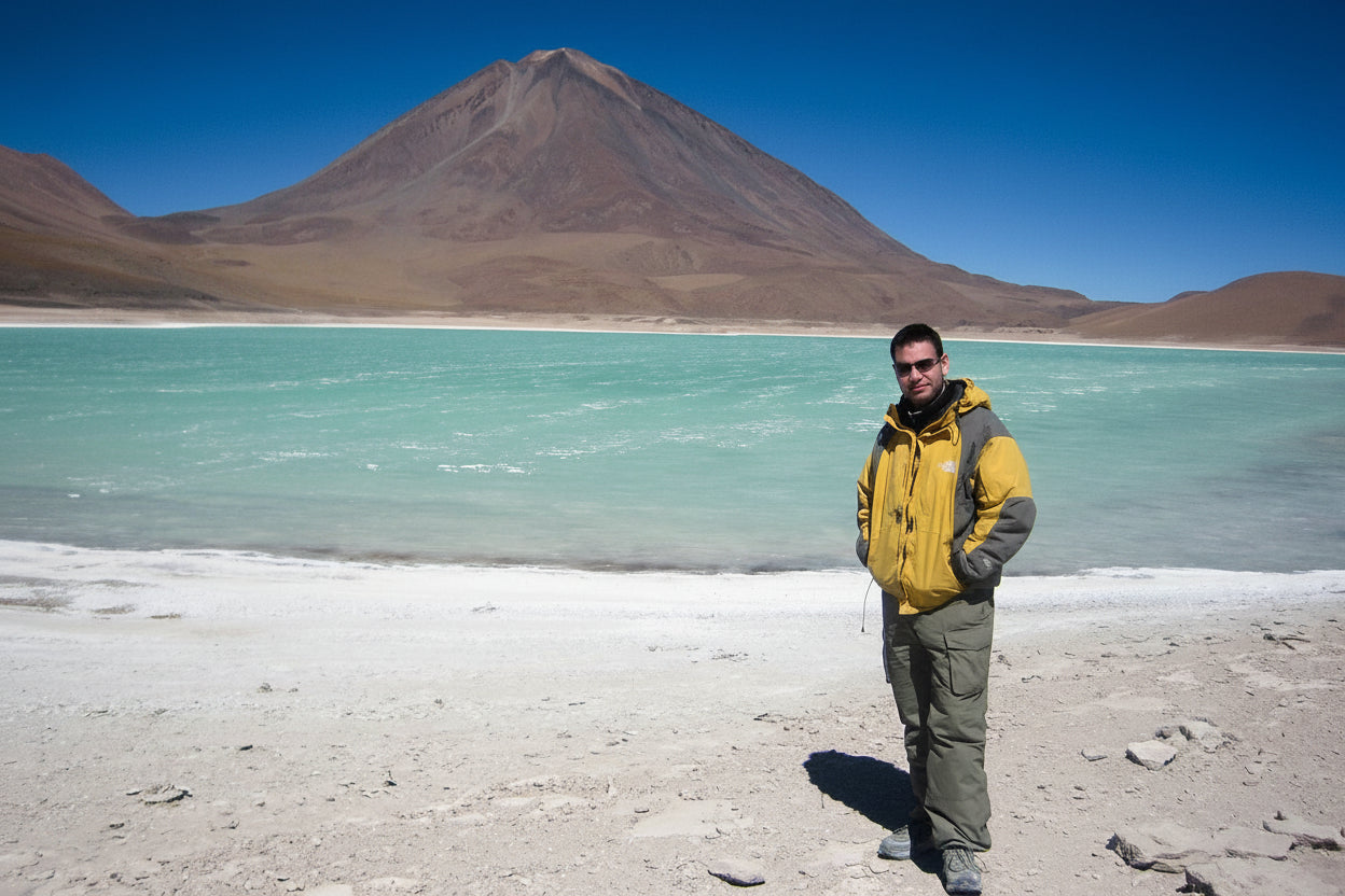 Traveller standing in front of a turquoise laguna verde with Llicancabyr volcano in the background in the south Lipez, Bolivia