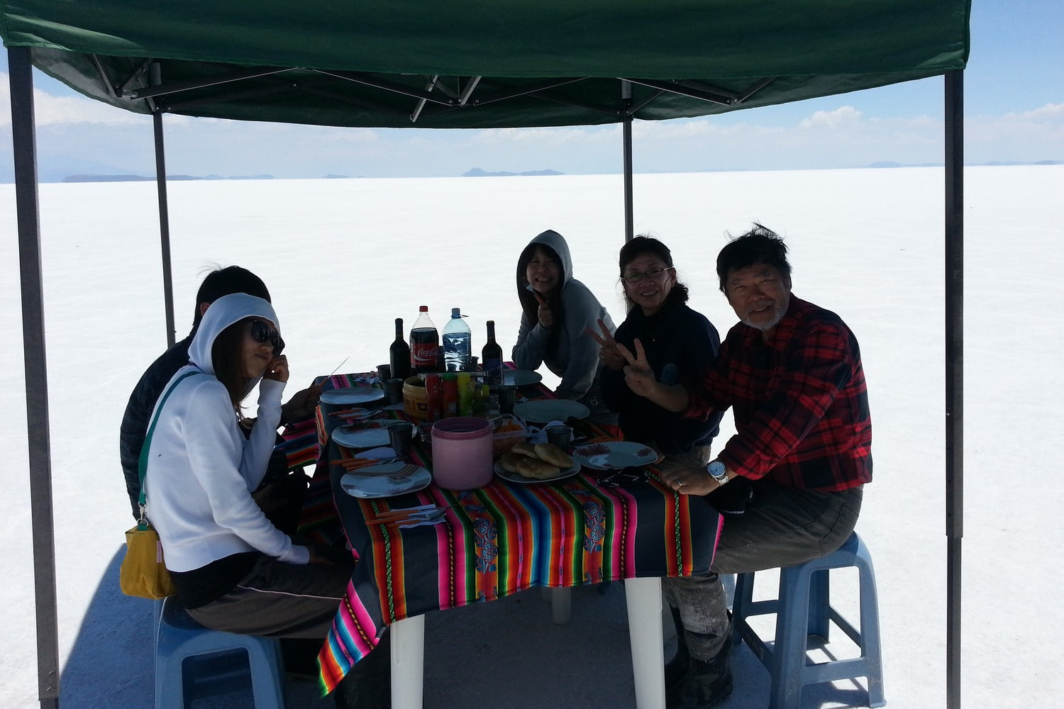 Group of people having lunch under a canopy at Uyuni salt flat, Bolivia