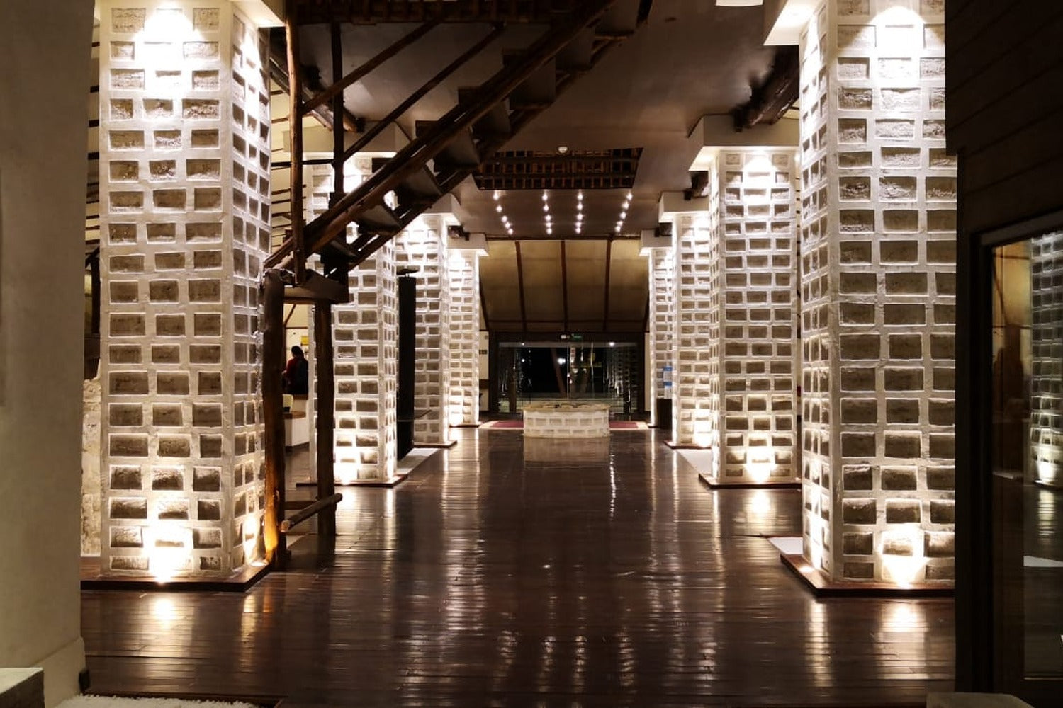 Modern interior with illuminated brick-patterned columns.