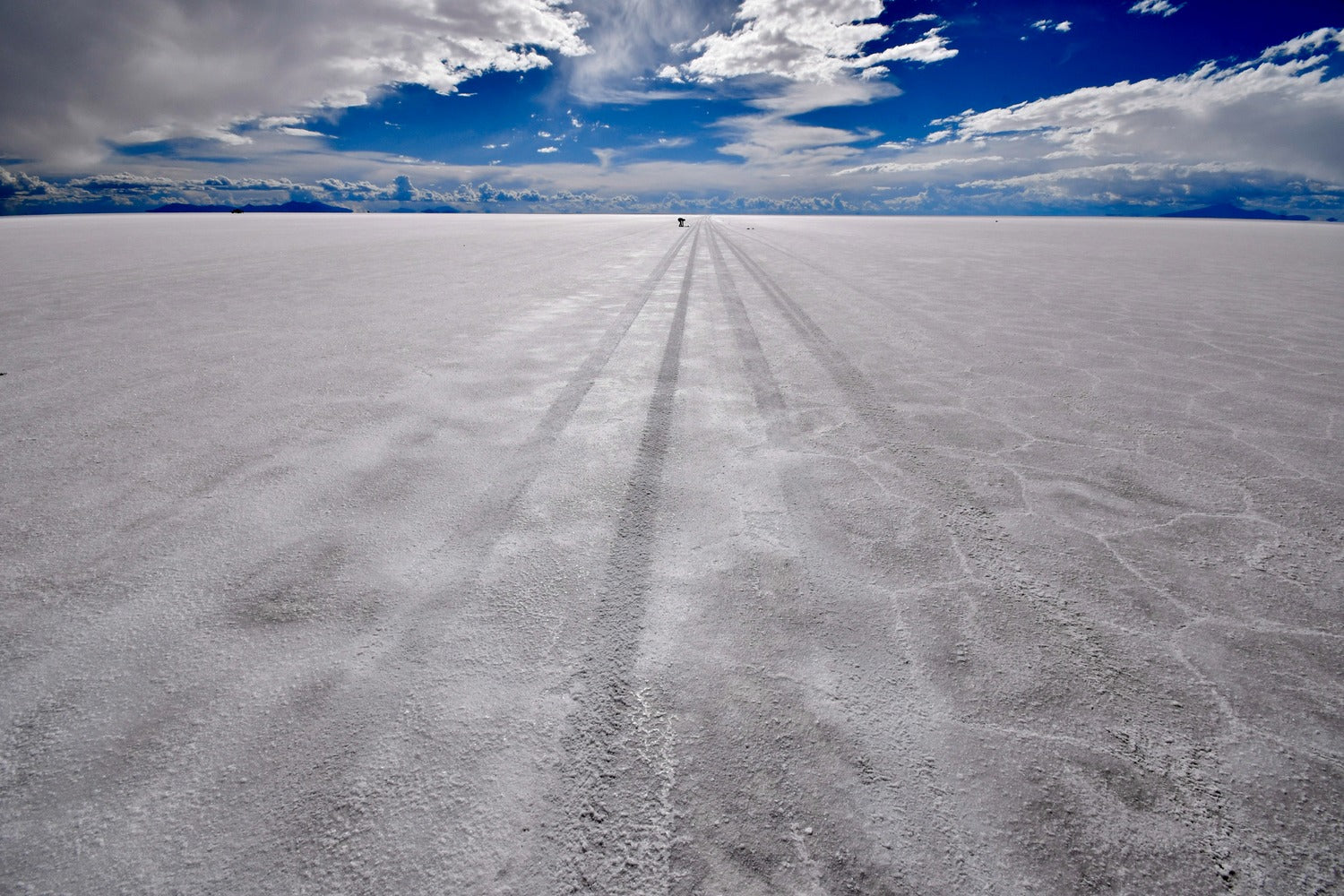 The infinite vastness of the Uyuni Salt Flats stretches to the horizon beneath dramatic skies.
