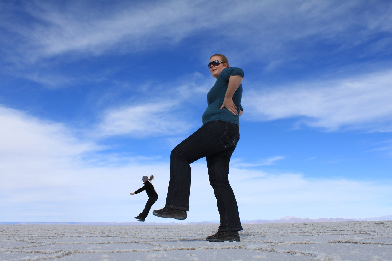 Person sparking optic effect, at Uyuni salt flat with a blue sky in the background