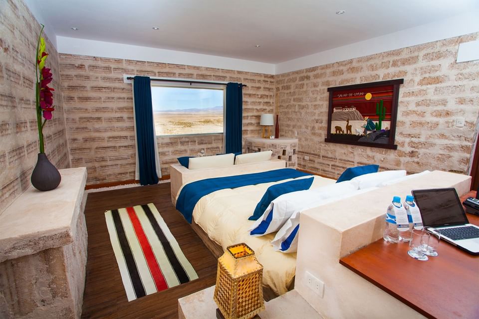 Modern bedroom with brick walls, bed, desk, and decor.