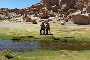 Two people standing on a grassy area at valle de las rocas Lipez, Bolivia